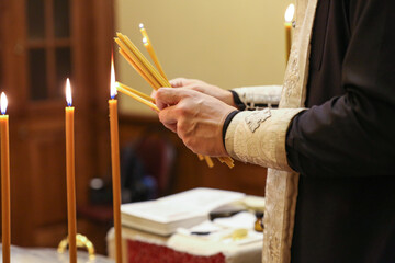 the priest lights candles for the rite of baptism