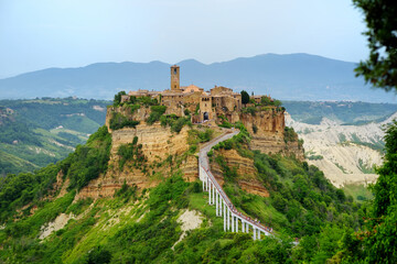 Naklejka premium Summer evening view of famous Civita di Bagnoregio town, beautiful place located on top of a volcanic tuff hill overlooking the Tiber river valley