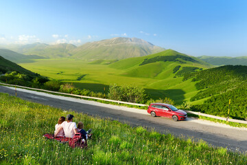 Family of three exploring the Piano Grande, large karstic plateau of Monti Sibillini mountains and one of the greatest tourist attractions in the area.