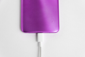 Purple cell phone connected to USB cable type C - Charging