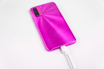 Pink cell phone connected to USB cable type C - Charging