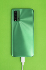 Green cell phone connected to USB cable type C - Charging