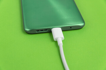 Green cell phone connected to USB cable type C - Charging