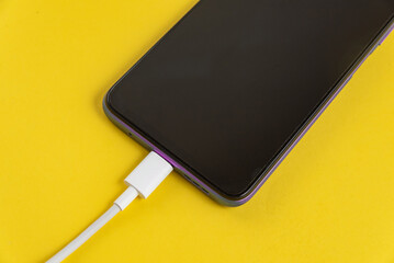 Purple cell phone connected to USB cable type C - Charging