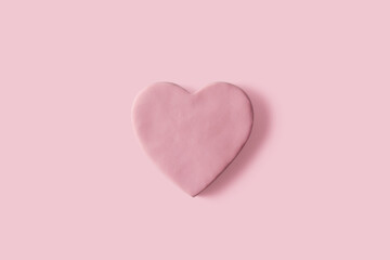 Handmade heart with pink plasticine on pastel background, copy space. Valentine's day card