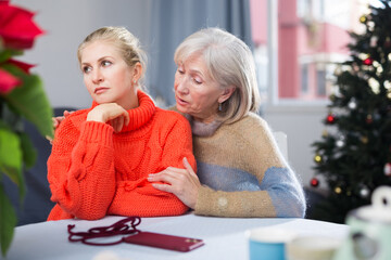 Mature woman gently hugged her adult, somewhat upset daughter, who came to visit her before...