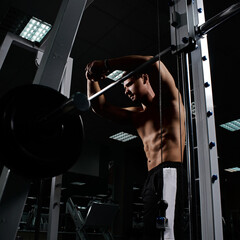 Muscular athletic young man resting after exercises in gym