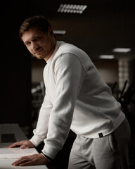 Muscular athletic bodybuilder fitness model posing after exercises in gym