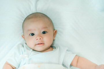 Adorable, Asian newborn. Baby boy looking camera and smile happy face. Little innocent new infant child in first day of life. Mother day concept.