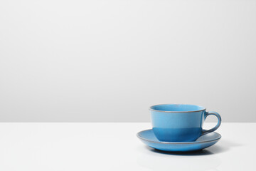 Obraz na płótnie Canvas 白背景の中の青いコーヒーカップ