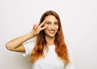 Fototapeta premium cheerful excited woman with long red hair showing peace sign