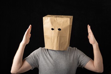 Man wearing a paper bag over his head and making touchdown sign