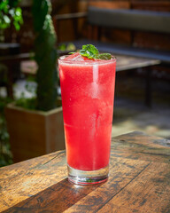 Trago sin alcohol color rojo con una menta arriba (jugo de sandia)