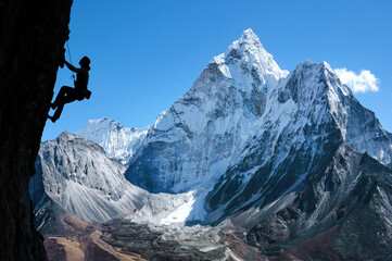 Rock climber on a route with amazing background view on Ama Dablam in the Everest Region of the...