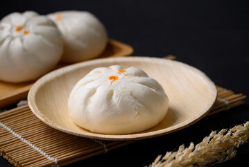 Steamed Chinese bun stuffed with minced pork, egg yolk or sweet on natural plate, Asian food