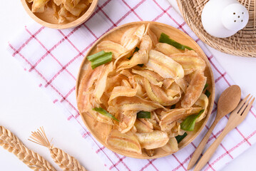 Banana chips or banana crisps on wooden plate ready to eating, Delicious snack, Top view