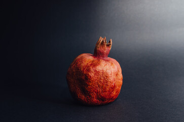 Dried red garnet on a dark background, rough texture of the peel of the fruit. space for text
