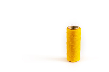 A coil of yellow thread. Spool of colored threads on a white background. Waxed sewing thread for leather crafts.