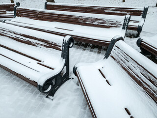 storage place for benches in the park at wintertime. benches under a layer of snow after a snowfall.