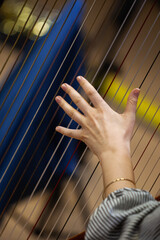 Woman's hand on harp strings