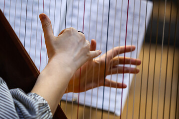 Hands of a woman playing the harp