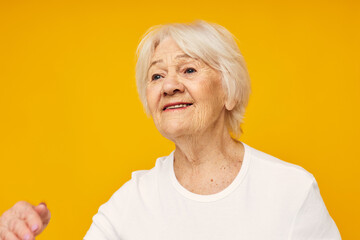 elderly woman in casual t-shirt gestures with his hands isolated background