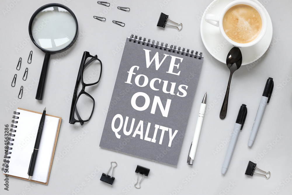 Poster we focus on quality. notepad on gray background with text