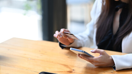 Cropped shot young businesswoman making payment online on her smart phone.