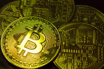 Five BTC coins on a dark background. Bitcoin cryptocurrency. Blockchain technology. Close-up.