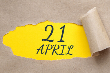 April 21. 21th day of the month, calendar date.Hole in paper with edges torn off. Yellow background is visible through ragged hole.Spring month, day of the year concept