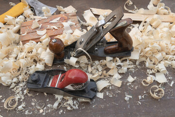 Close up shot of plane tools on the table surrounded by wood shavings