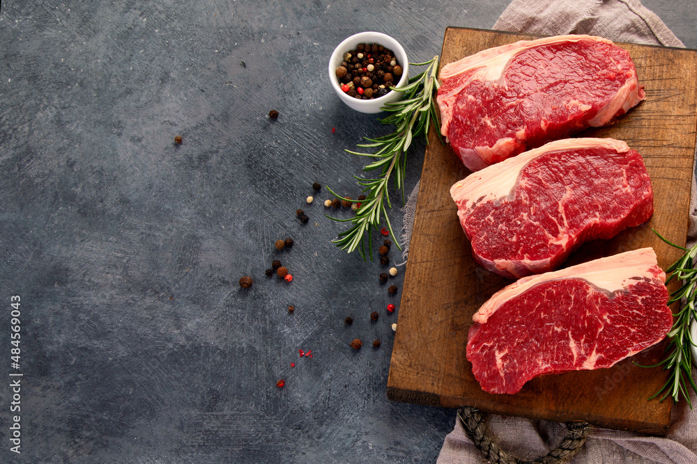 Wall mural Raw steak on dark background.