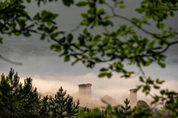 Amazing view through a forest on the Svanetian defense towers in the village of Mestia in the Greater Caucasus Mountain Range, Upper Svaneti,Country of Georgia.Morning fog covers the towers.Mystical