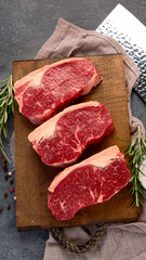 Raw steak on dark background.