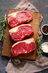 Raw steak on dark background.