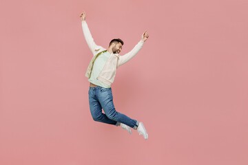 Full size young overjoyed exultant jubilant happy fun man 20s in trendy jacket shirt jump high with...
