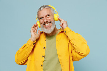 Elderly minded gray-haired mustache bearded man 50s wear yellow shirt headohones listen to music...