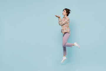 Full body side profile view fun young happy woman 20s wearing casual brown shirt jump high blow air...