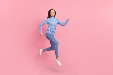 Fototapeta na wymiar Photo of sporty energetic lady jump run fast hurry wear blue turtleneck jeans shoes isolated pink color background