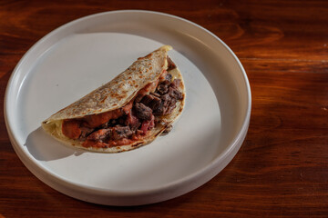 Quesadilla with meat on a white plate