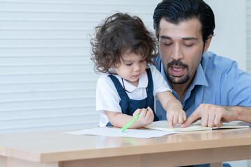 Fototapeta na wymiar Caucasian young father with beard teaching little cute daughter writing or drawing on book in living room after work. Happy handsome dad help kid learning at home