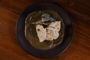 Roasted tortillas resting on mole verde