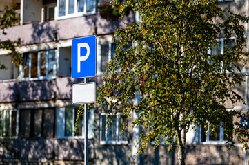parking road sign with a blank information plate on the background of a residential house, mock-up
