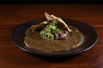 Roasted tortillas resting on mole verde