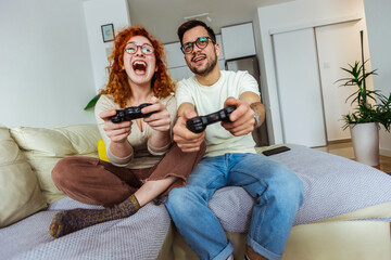  Loving couple are playing video games at home.