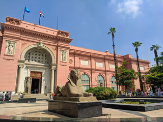 Cairo, Egypt - September 30, 2021: View of the Cairo National Egyptian Museum against the blue sky. Groups of people stand near the entrance waiting for the tour.