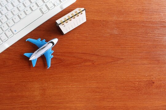 Travel, vacation concept. Top view image of keyboard, calendar and toy plane with copy space