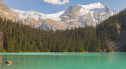 The lake with turquoise water is surrounded by coniferous forests and mountains. Joffre Lakes BC...
