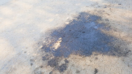 Oil stains on asphalt roads. Closeup of old oil spills leaking from the car onto the paved road with copy space. Selective focus