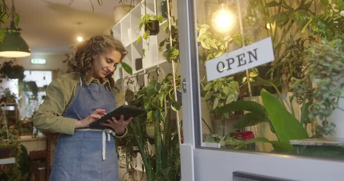 Female Florist Entrepreneur Working on Digital Tablet in Plant Store